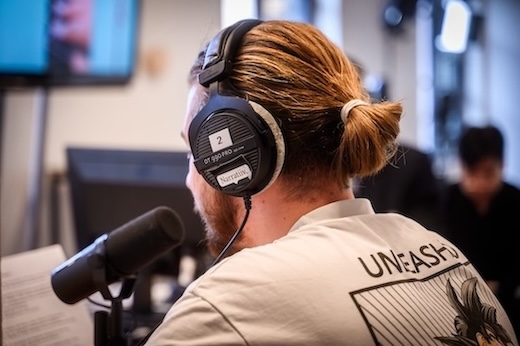 Étudiant en podcast devant un micro en projet étudiant